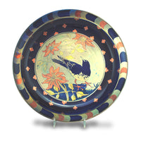Image shows a bowl painted in blue, gold and peach tones depicting a bird and flowers.
