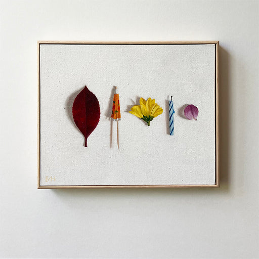 an original painting of a dark red leaf, an orange cocktail umbrella, a yellow flower, a blue and white birthday candle and a purple petal all in a line, against a pale background.