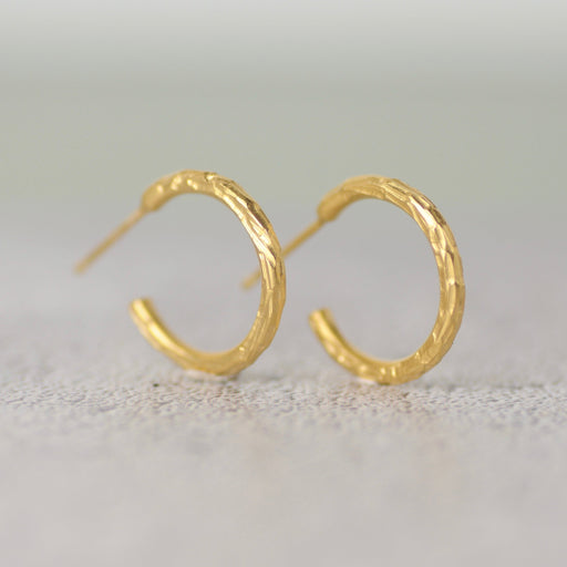 A pair of small, gold hoop earrings by jewellery designer Rebecca Burt.