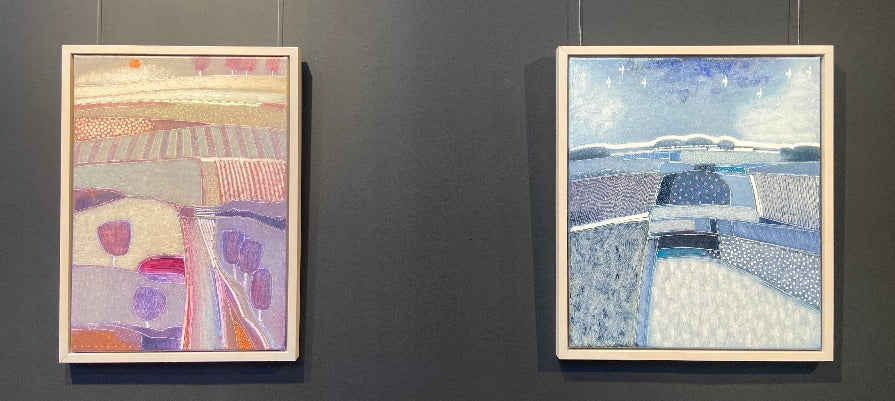 Calm Before the Storm by Rob van Hoek, a purple-toned landscape painting next to a blue-toned landscape painting at The Biscuit Factory Newcastle