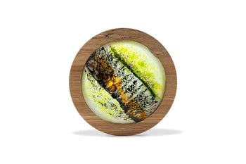 Buy View and buy original glass artwork by Helen Grierson online at The Biscuit Factory. Image shows a circular piece of coloured glass in green, orange and brown framed in a circular piece of oak-coloured wood.