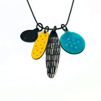 Hand crafted jewellery for sale at Newcastle art gallery. Image shows a necklace with four large pendants of varying shapes. Black, yellow and blue colours.