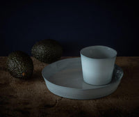 Original art for sale by Becky McKenzie at The Biscuit Factory. Image is tinted dark and features a cup and saucer, and two avocados.