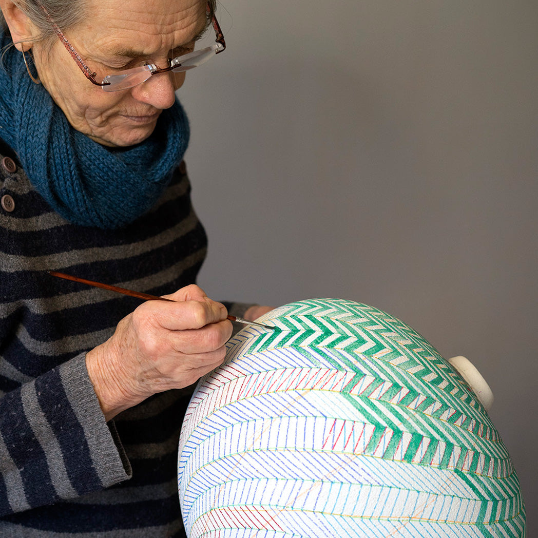 Shop original raku ceramics by Ilona Sulikova at The Biscuit Factory. Image shows Ilona painting one of her pieces.