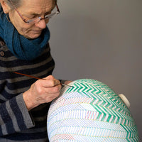 Shop original raku ceramics by Ilona Sulikova at The Biscuit Factory. Image shows Ilona painting one of her pieces.