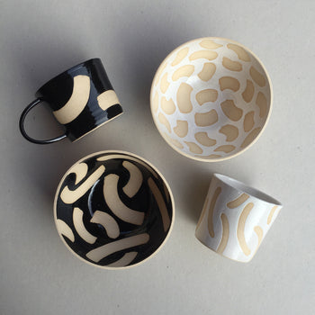 Beautiful hand-made ceramics to view and buy in Newcastle, at The Biscuit Factory. Image shows ceramic cups and saucers in bold black, white and cream prints.