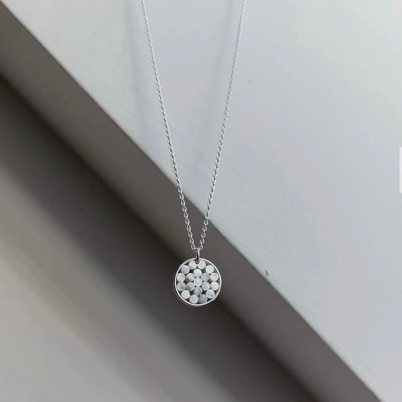 Millefleur Pendant by Emily Collins, chain with a pendant made lots of silver discs in a round silver frame. | Contemporary minilmalist jewellery for sale at The Biscuit Factory Newcastle