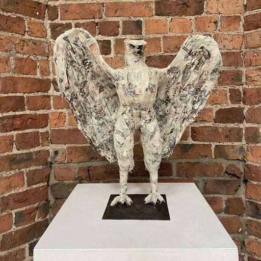'Buy 'Standing Eagle' mixed media original sculpture by Zoe Robinson online at The Biscuit Factory. Image shows a sculpture of an eagle displayed on a plinth against a brick wall.'
