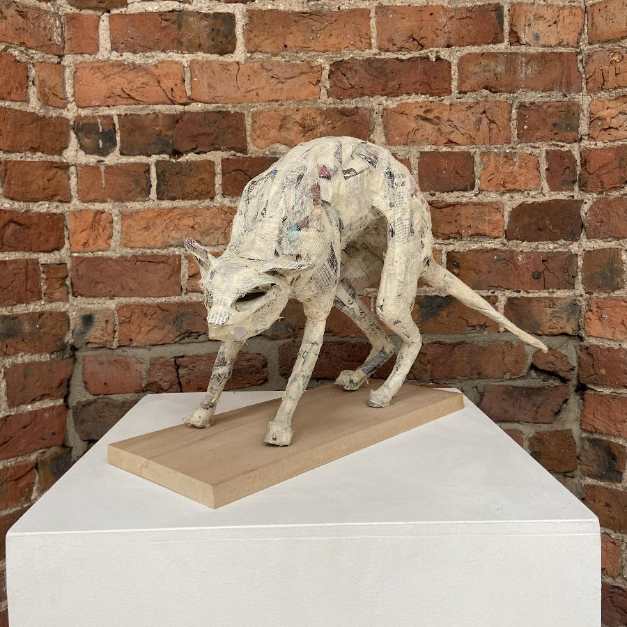 'Buy 'Cat' original handmade mixed media sculpture by Zoe Robinson online at the Biscuit Factory. Image shows a mixed media sculpture of a Cat displayed on a plinth against a brick wall. The cat is white.'