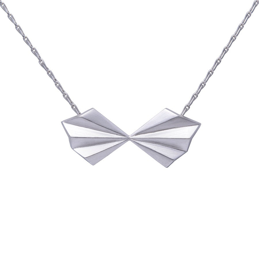 Pleated Bow Necklace by Alice Barnes, contemporary jewellery at The Biscuit Factory. Image shows a silver necklace in a bow shape with folds in the metal/
