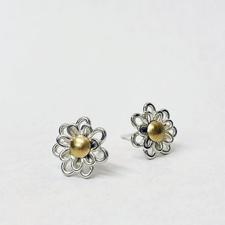 Image shows a pair of silver daisy shaped ear studs with gold centres, made by jeweller Yuki Kokai. For sale at The Biscuit Factory Newcastle.