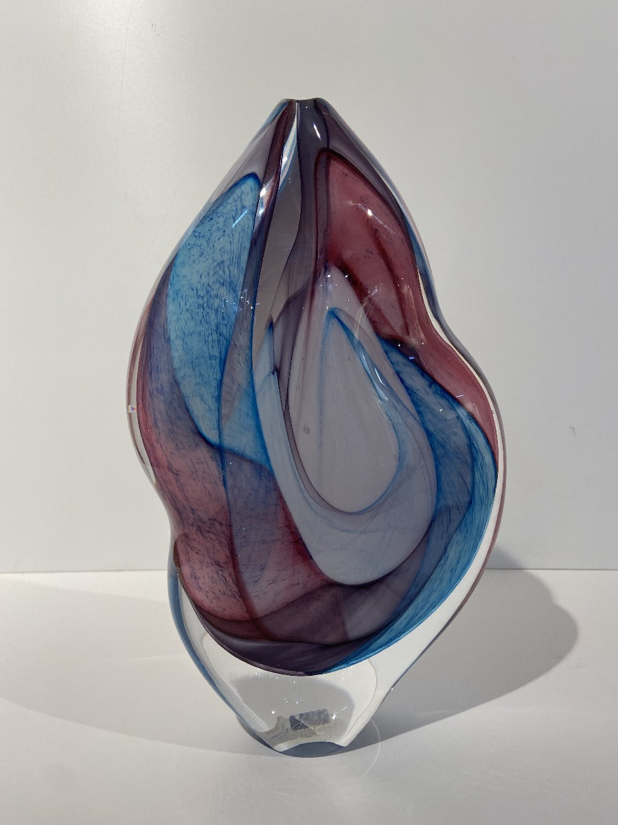 Buy 'Pastel Organic Stoneform' a glass sculpture by Peter Layton online at The Biscuit Factory. Image shows a glass sculpture with a curvy shape. It has swirls of pink, blue and white beneath a clear glass surface.