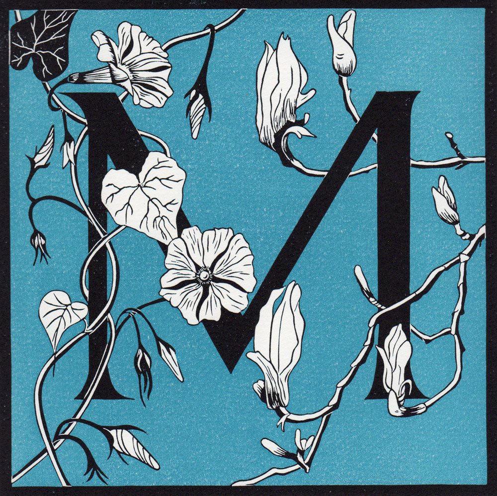 View and buy typography prints by Julie North at The Biscuit Factory. Image shows a blue square print with a black border featuring the letter M at the centre decorated by white flowers