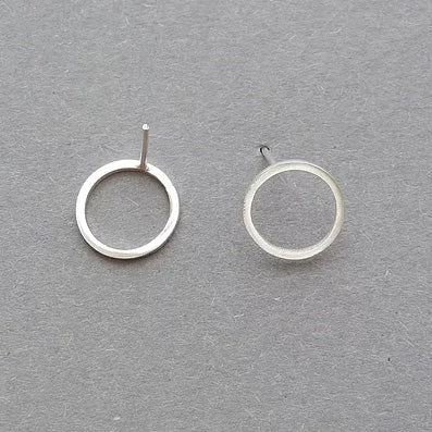 Silver circle ear studs by Elin Horgan at The Biscuit Factory. Image shows a pair of earrings that are silver circles, against a grey background