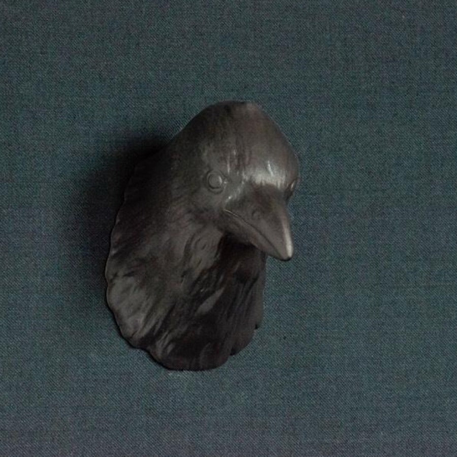 'Buy 'Raven Head' handmade ceramic sculpture by Jackie Summerfield online at The Biscuit Factory. Image shows a black raven head ceramic sculpture set against a grey background.'